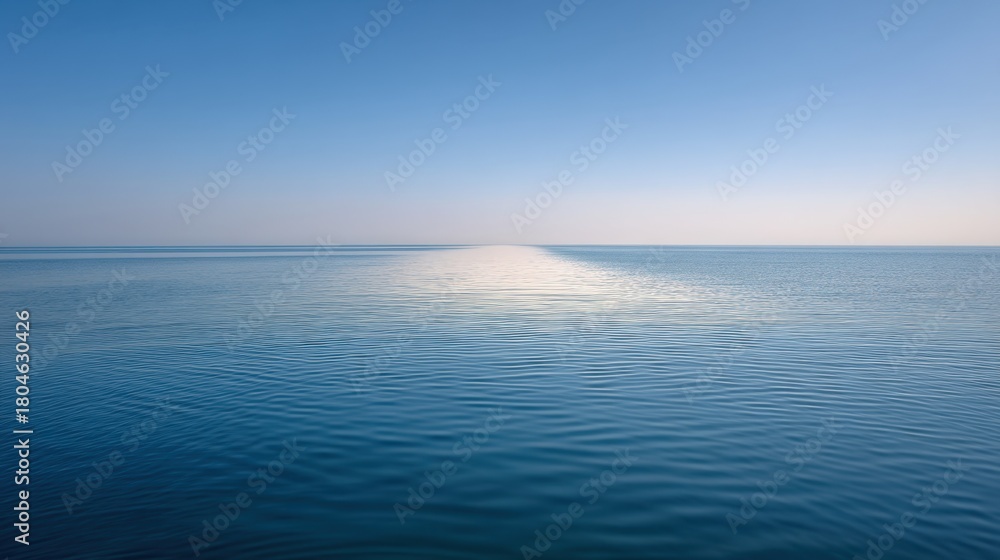 Obraz premium Serene Blue Ocean with Tranquil Calm Waters Under Bright Sky Emitting Soft Reflections and Gentle Ripples Emphasizing Peaceful Seascape Beauty