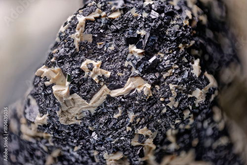 Macro perovskite on calcite from Hatanga river basin, Krasnoyarsk region. Rare association of shiny black crystals and light mineral aggregate. Northern Russia.
