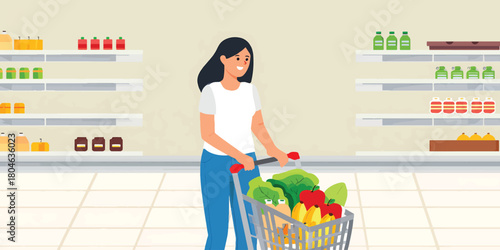 Young woman pushing a shopping cart full of groceries in a supermarket