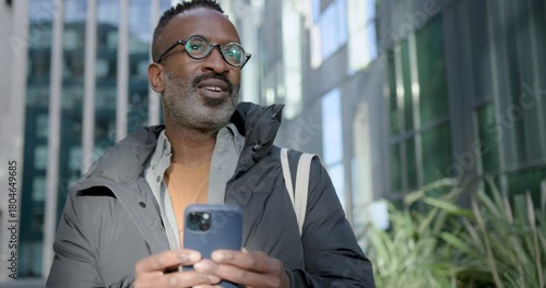 Businessman Looking at Smartphone in City