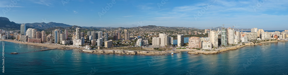 Fototapeta premium Aerial View of Calp, Spain and the Extensive Condos, Villas, and Prime Real Estate by the Majestic Peñón de Ifach on the Mediterranean Coast