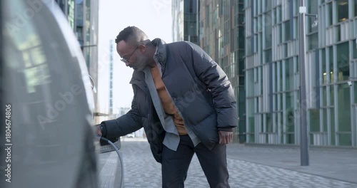 Man Charging Electric vehicle in City street