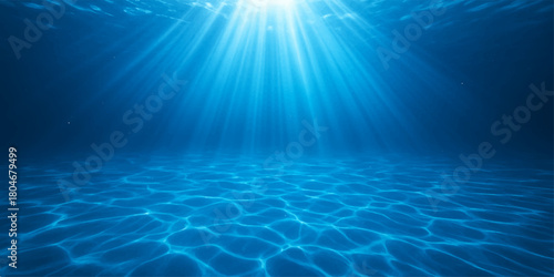 Deep blue ocean water with sunlight rays bursting through the surface shining bright