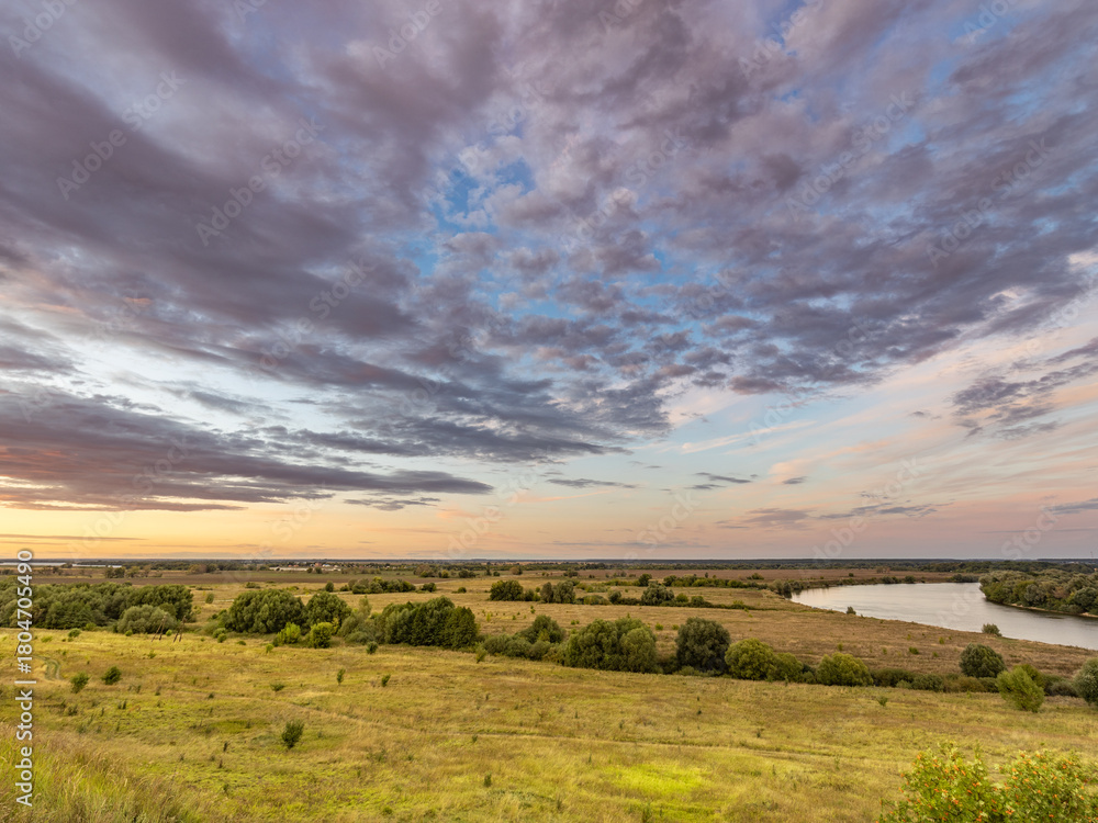 Fototapeta premium Large field with a river running through it