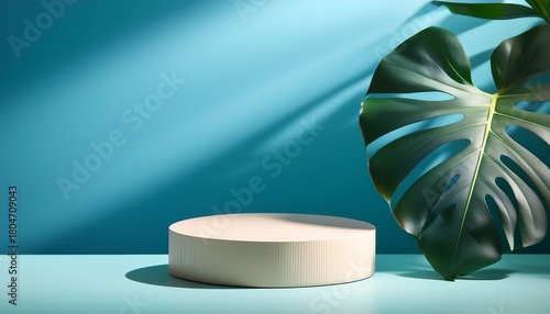 minimalist round podium with tropical monstera leaves and soft shadows on a blue wall creating a natural scene for product display