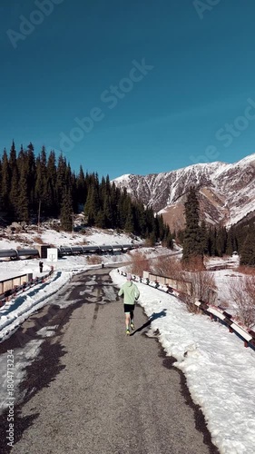 Man running at the road in the mountains