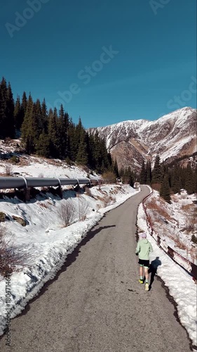 Man running at the road in the mountains