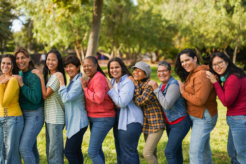 Multiracial women standing in a line and smiling on camera - Multi generational group of people having fun together at park - Feminism, community and international women's day