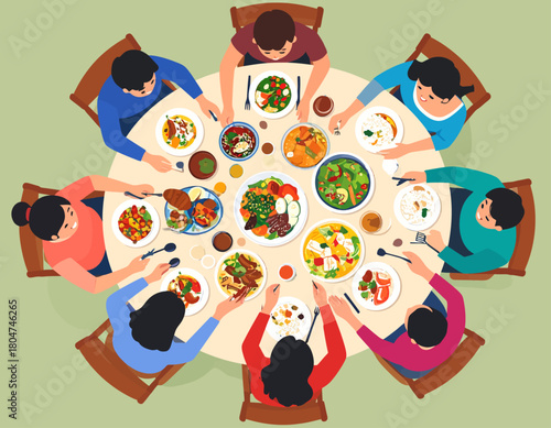 An overhead view of eight people sitting around a round table, enjoying a meal with various dishes and cutlery, in a warm and inviting setting.
