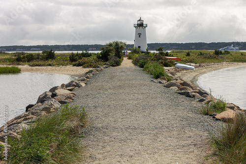 Martha's Vineyard, Massachusetts. The Edgartown Harbor Lighthouse, white tower with a black lantern, rises from sand and marsh, framed by dunes against a clear blue sky