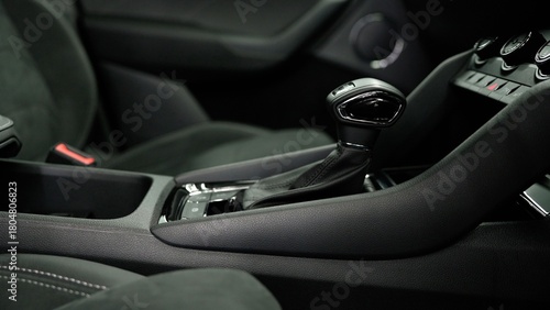 Modern car interior details featuring the dashboard, manual gear shift, and passenger seat with alcantara upholstery and white stitching