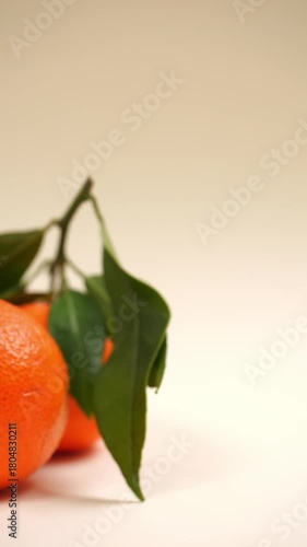 Video verticale, clementine con foglie su sfondo chiaro