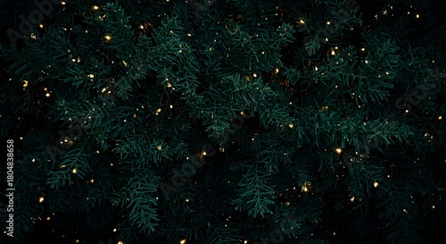 A close up of a christmas tree with small yellow lights scattered throughout the branches