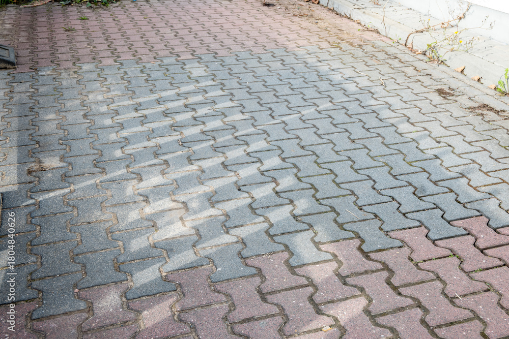 Fototapeta premium City road sidewalk repair with much pavement tiles black and red colour.