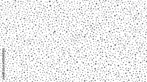 A dense pattern of small and medium sized grey dots scattered randomly across a clean white background creating a textured surface