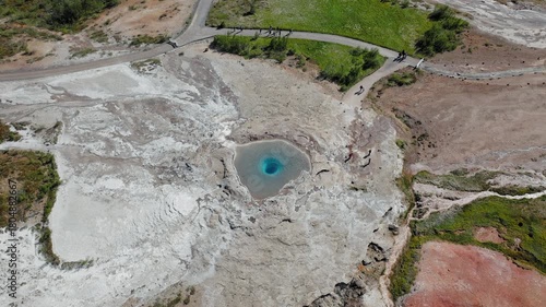 Aerial view of Strokkur Geyser’s hot spring basin. Drone footage captures visitors standing around the bubbling pool while waiting for the next eruption.