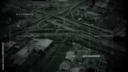 Aerial surveillance, military reconnaissance view of a complex highway interchange with HUD targeting graphics, creating a cinematic spy-drone atmosphere and intelligence-operation mood