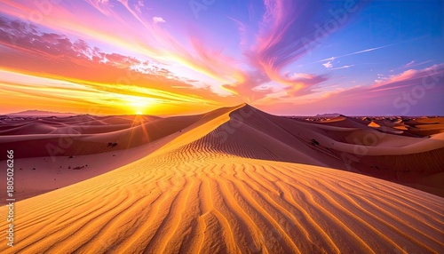 Fototapeta Naklejka Na Ścianę i Meble -  A breathtaking desert landscape bathed in the warm glow of a vibrant sunset, with undulating sand dunes stretching towards the horizon under a colorful sky.