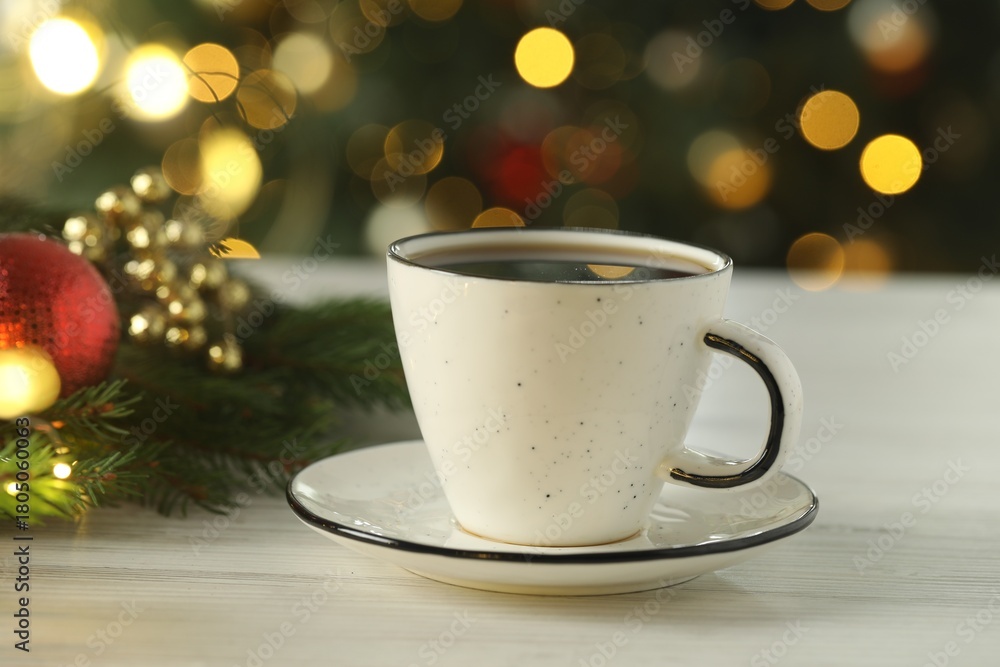 Obraz premium Aromatic coffee and Christmas decor on white wooden table against blurred lights, closeup