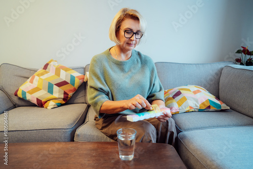 Middle age female holds pill box in her hands. Woman in menopause taking daily dose of minerals for skin and health care, boost metabolism. Vitamin A, D, C deficiency prevention treatment.