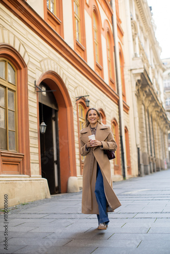 Woman in beige coat walking...