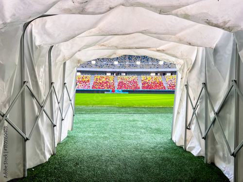 Massive Soccer Stadium tunnel.View of empty stadium. Green grass on a sport Arena. Empty Football Soccer Stadium Tribune. National arena with empty seats. Sport event on National Arena. 