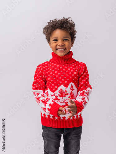 Fotografía little mulatto boy in a New Year's sweater on a white background in a studio