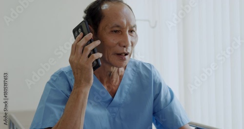 Hospital concept of 4k Resolution. Asian patient talking on cell phone in hospital room.