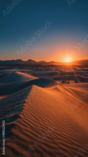 Stunning Desert Landscape With Rolling Dunes and Mountain Backdrop at Sunset