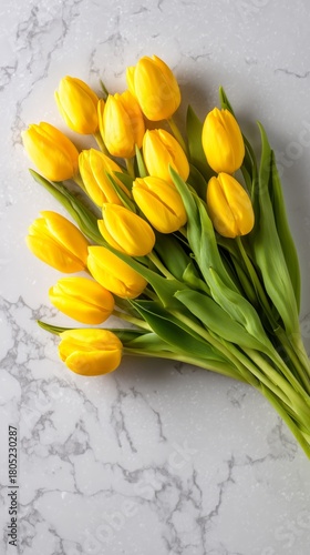 Bright Yellow Tulips Arranged Beautifully on a Marble Surface for Spring Deco...