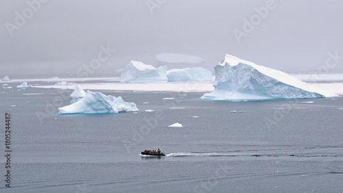 A zodiac boat makes its way through icebergs on an excursion for adventurous tourists, in Antarctica.