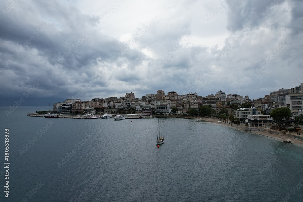 Obraz premium Aerial view of Sarande, a historic Albanian harbor town on the Ionian coast, featuring waterfront landmarks, boats, and Mediterranean architecture.Saranda city