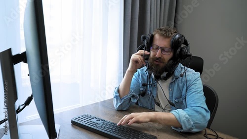 Rush hour at work. Home office, remote work concept. A call center employee, wearing a wired headset, is actively consulting and simultaneously typing on the keyboard. 