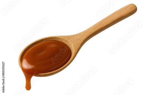 Caramel sauce dripping from wooden spoon
