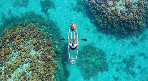 Fototapeta Naklejka Na Ścianę i Meble -  Aerial view of man kayaking over clear coral reef waters