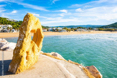 Fototapeta Naklejka Na Ścianę i Meble -  Heart-shaped rock sculpture framing the beach and blue sea at Peschici, Apulia, Italy