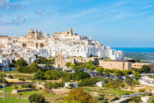 Panoramic view of the whitewashed hilltop town of Ostuni, known as the “White City,” with its cathedral and sea views in the background, Apulia, Italy