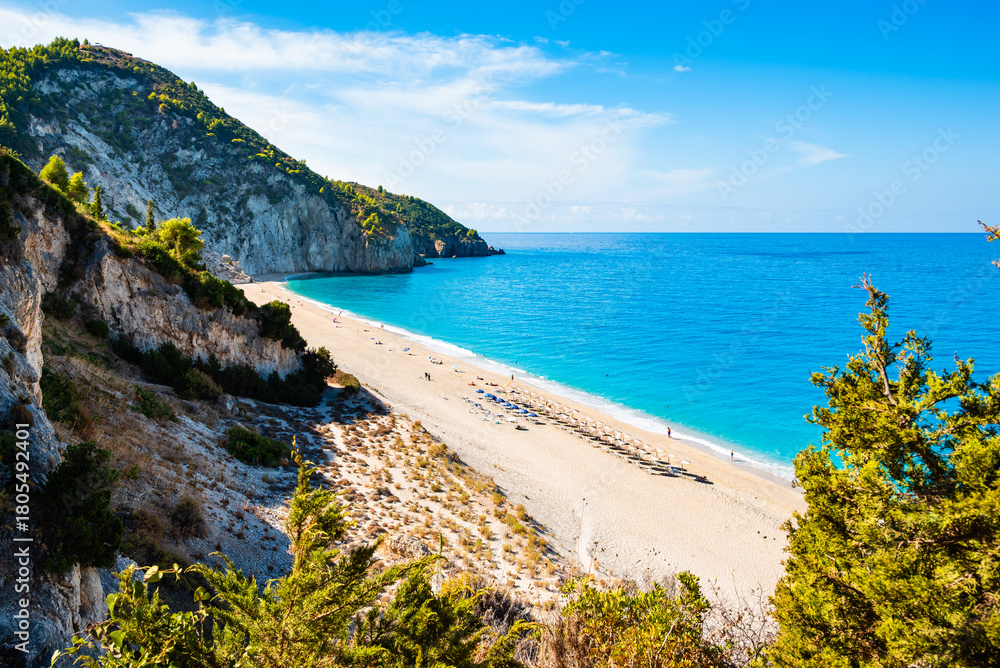 Fototapeta premium View of cliffs with green pine trees and Milos beach from high vantage point, Lefkada island, Greece