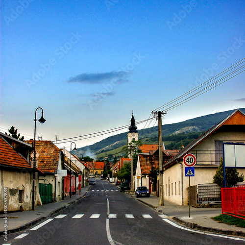 Fototapeta Naklejka Na Ścianę i Meble -  A street in a small town with a church tower in the background.