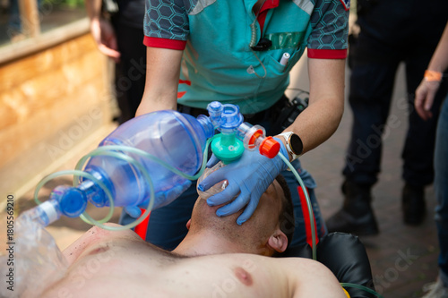 an ambulance worker administers rescue breaths to a victim during an exercise