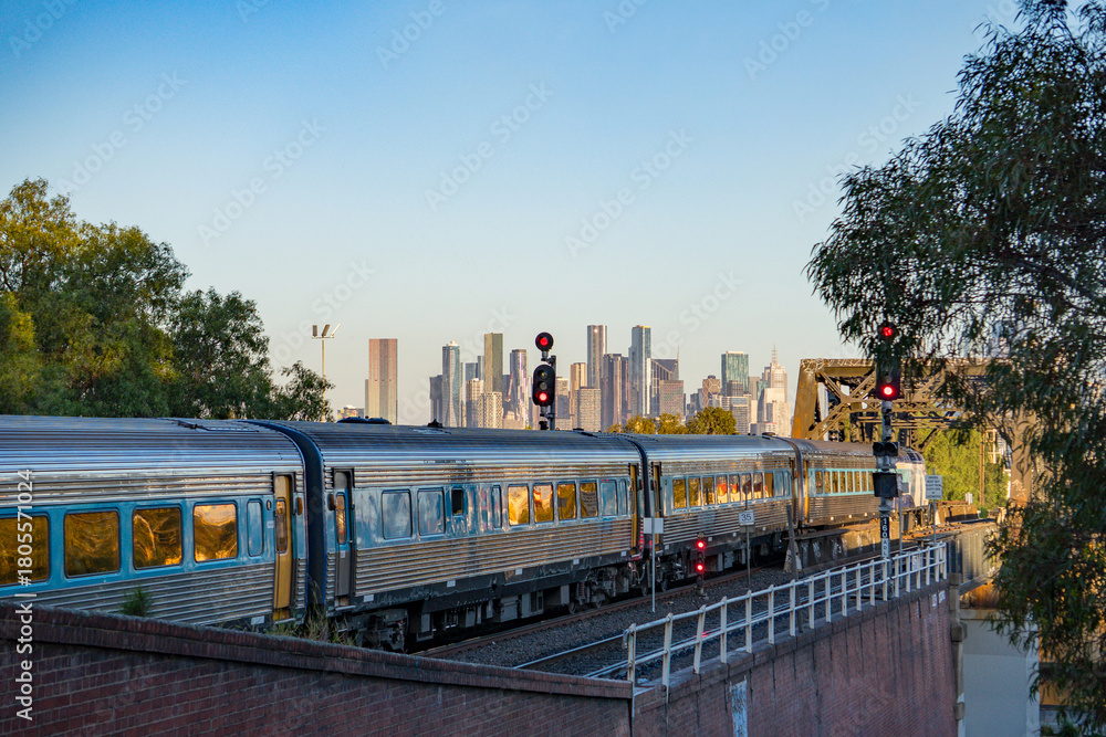 Fototapeta premium Melbourne city skyline with Metro train passing by, Skyline CBD Melbourne, View of Melbourne from Footscray.