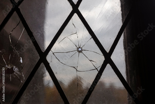 Impact damage creating radial cracks in leaded diamond pattern window glass