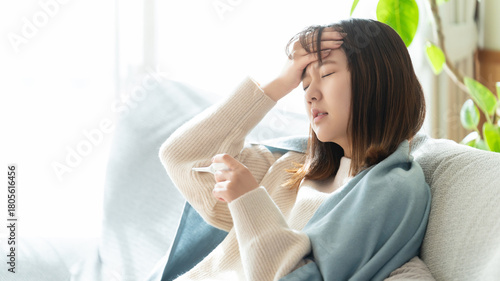 熱を測る体調不良の女性
