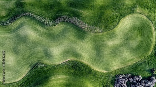 An aerial view showcases the undulating green fairways of a golf course, highlighting the precision of the landscaping.