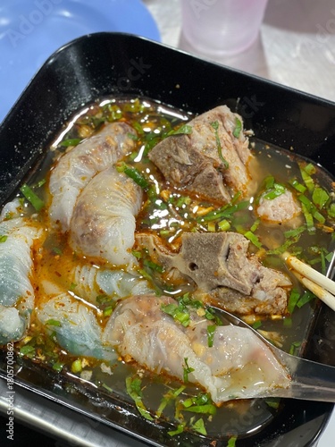 The closed up of Thai noodles. Asian noodle soup with beef meatball with fresh vegetable on wood table.