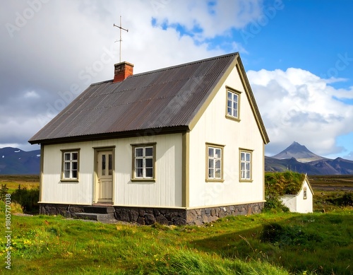 A charming, quaint, two-story house with a metal roof and small attached structure, situated in a green, grassy landscape