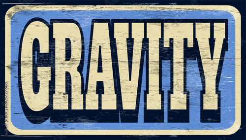 Aged and worn gravity sign on wood