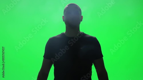 Silhouette of a Man Standing in Front of Green Screen with Smoke Effect