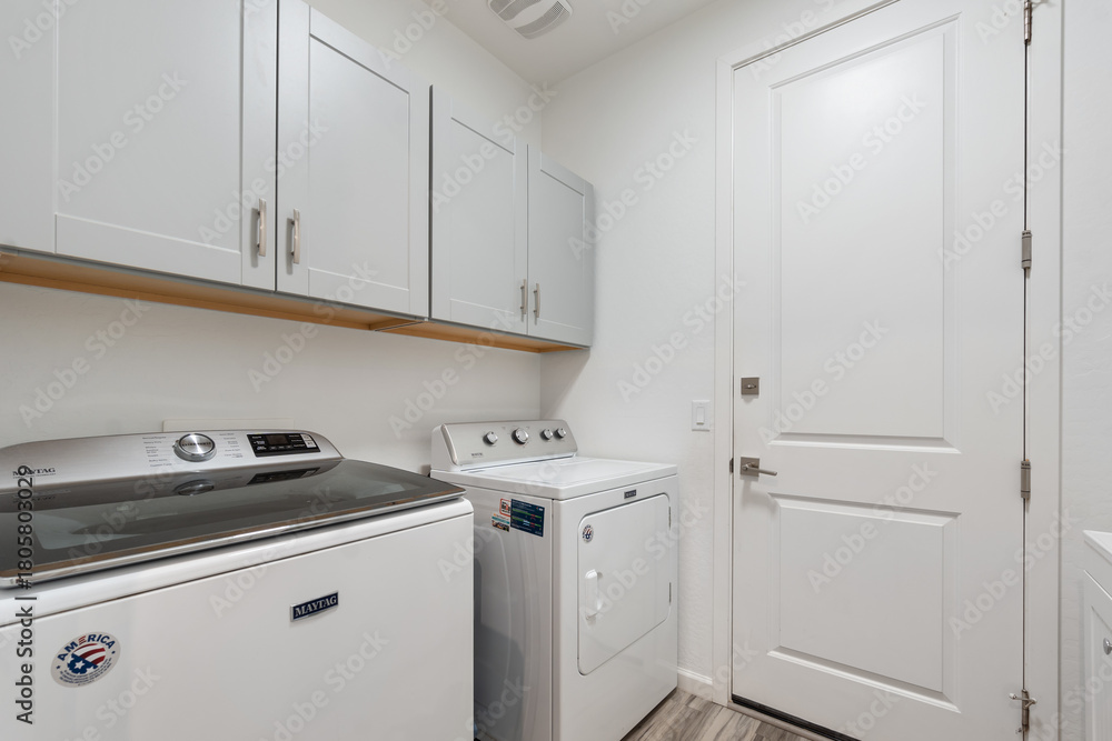 Fototapeta premium In a laundry room, there are two blue washers and matching dryers
