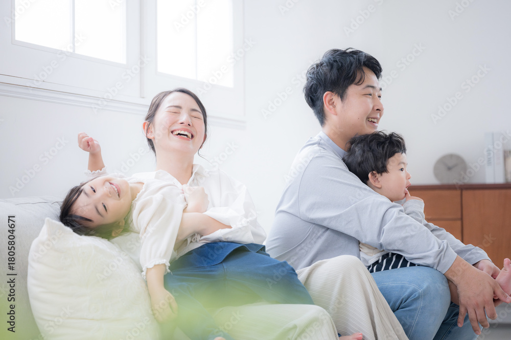 Fototapeta premium ソファで笑い合う家族団欒と幸せの瞬間 大笑いでわちゃわちゃ家族